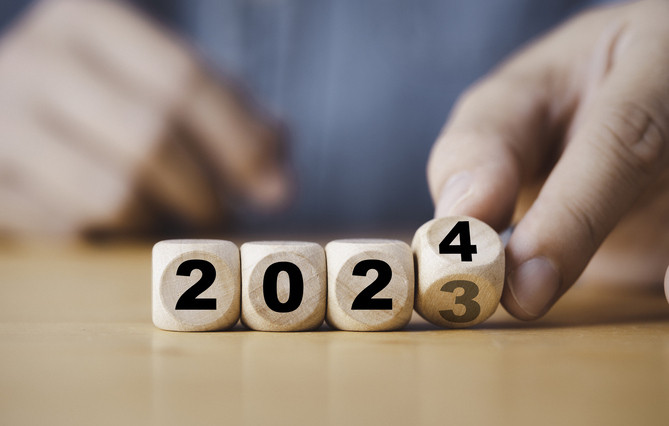 Hand flipping of 2023 to 2024 on wooden block cube for preparation new year change and start new business target strategy concept.