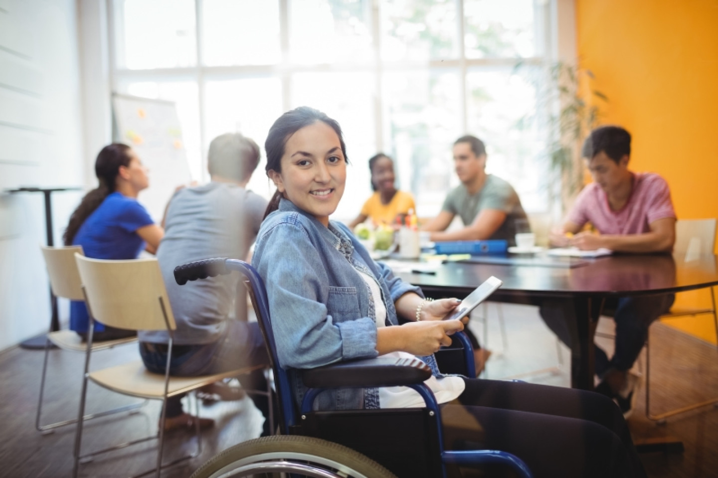 Portrait of handicapped business executive using digital tablet in office