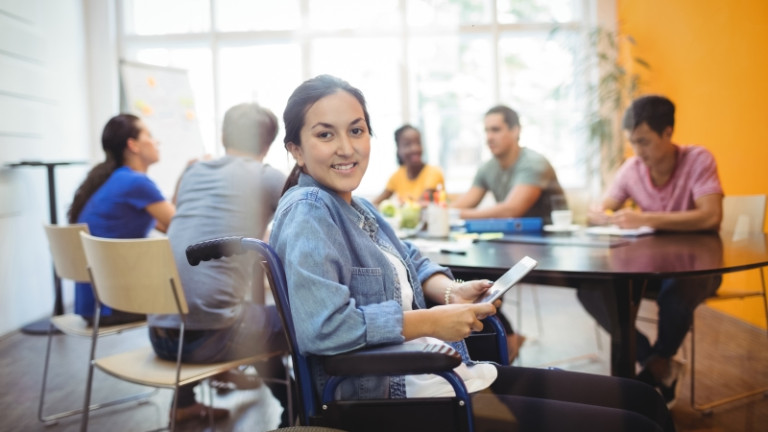 Portrait of handicapped business executive using digital tablet in office